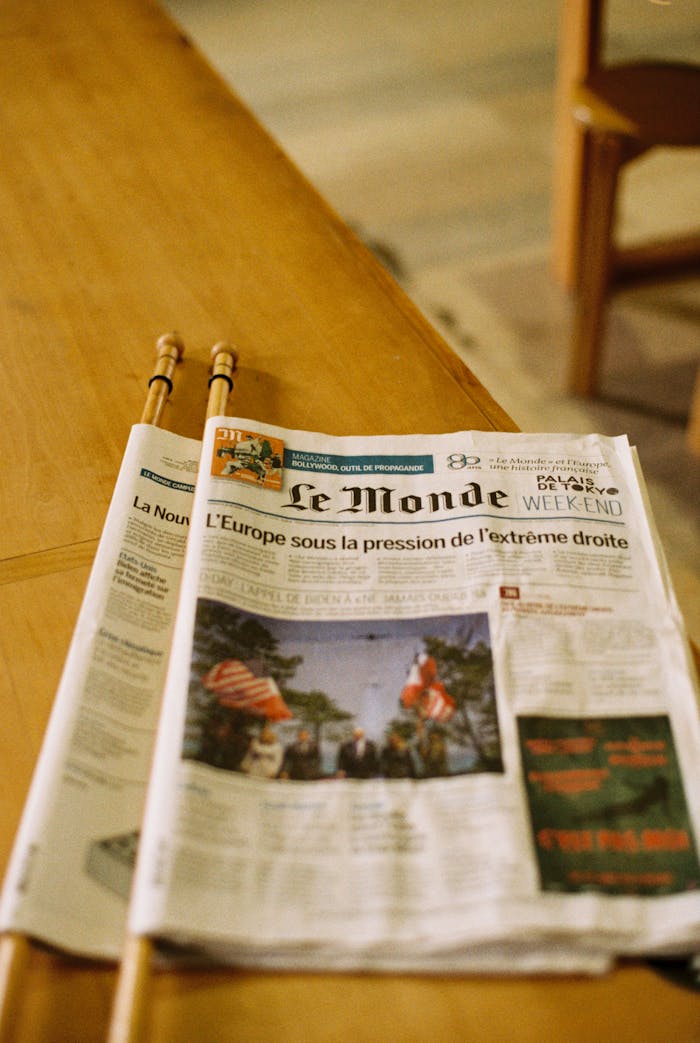 Le Monde newspaper placed on a wooden table, depicting European news.